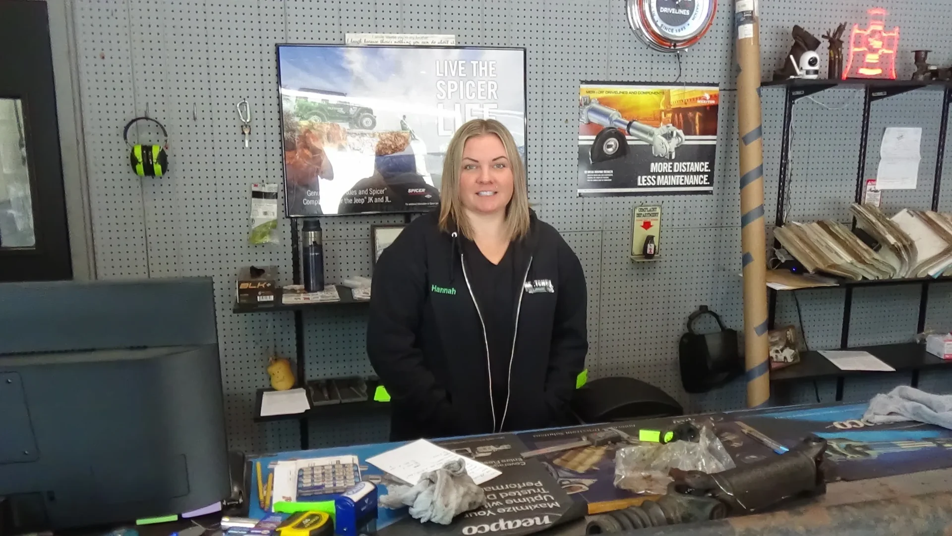A woman sitting at the counter of a car shop.